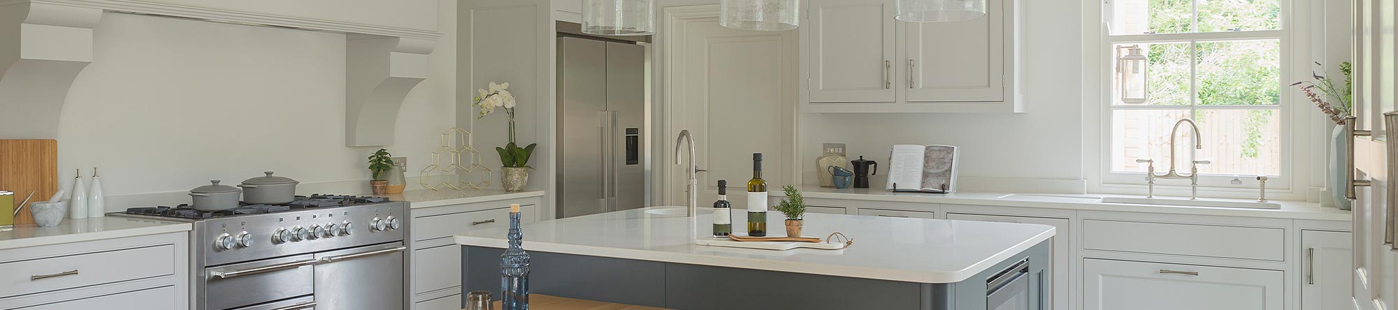 modern kitchen with white cabinets, large island, stainless steel appliances, and pendant lights