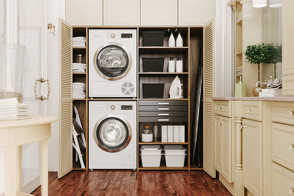 laundry room with stacked washers and shelves of supplies in an open closet