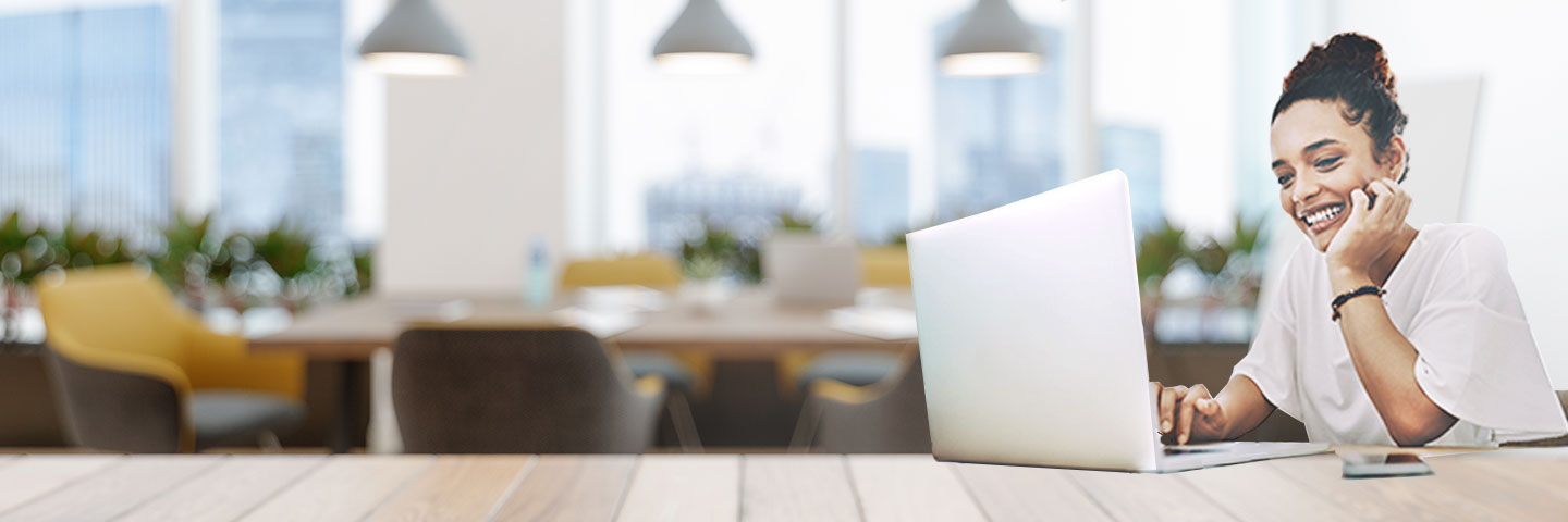 professional working remotely on a laptop in a modern open-plan office with contemporary furniture, ambient lighting, and collaborative workspace design