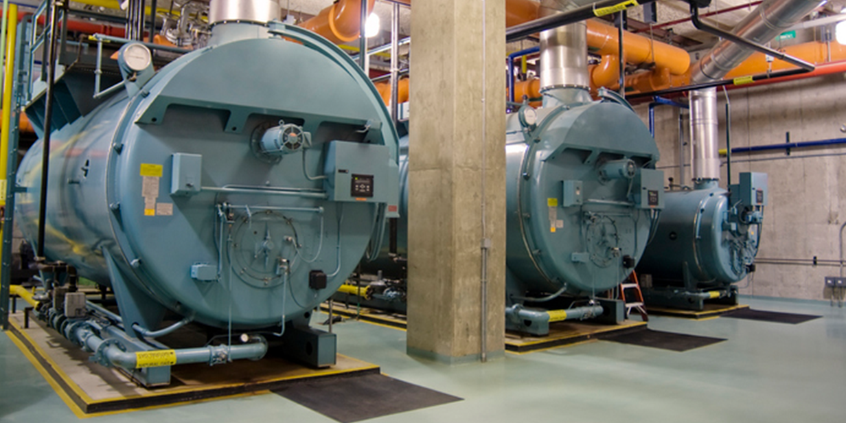 industrial boiler room with energy-efficient blue boilers, control panels, and piping system